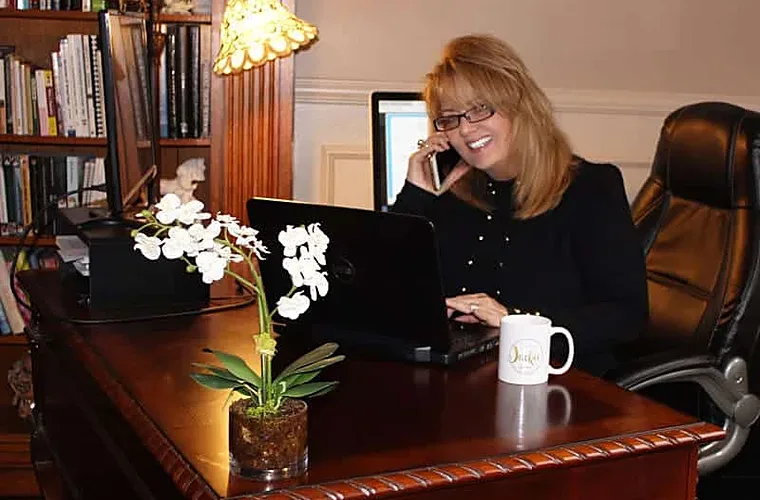 Jackie Barikhan taking a client call at her desk in the Huntington Beach office
